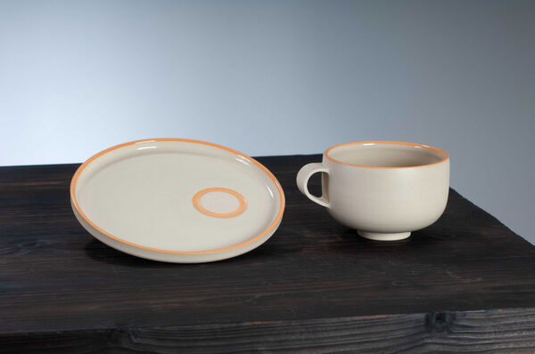 cappuccino cup and saucer set with orange rim side by side view