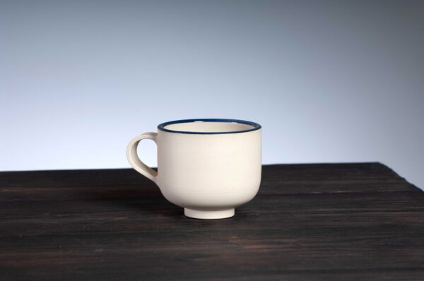 front view of coffee cup with navy rim