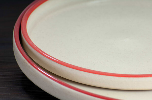 detail view of large and small plates with red rim